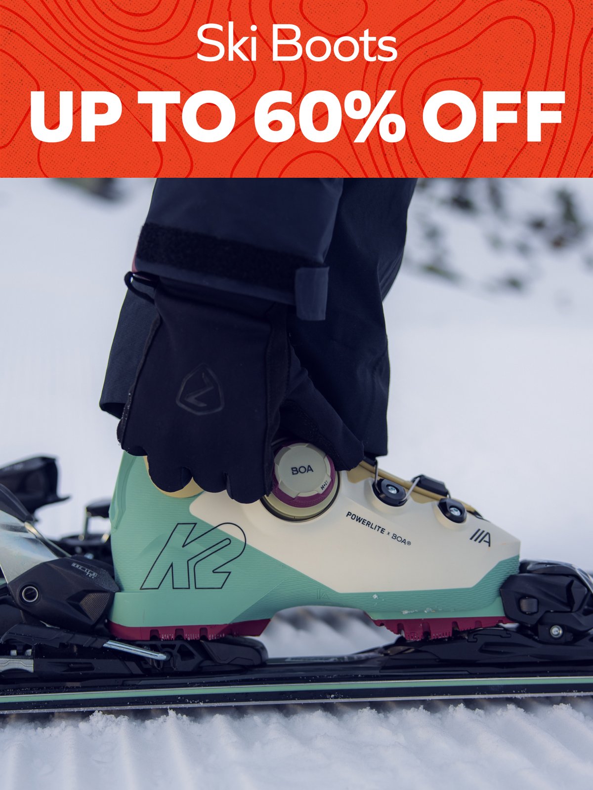 Ski Boots up to 60% off — gloved hand adjusting the BOA dial on a mint K2 ski boot clipped into a binding in the snow.